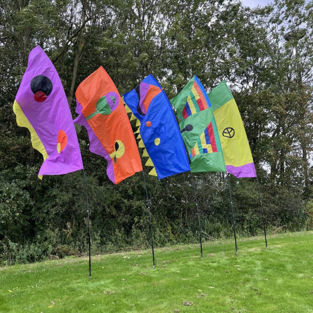 Handgemaakte stoffen vlaggen in opvallende kleuren, te huur per set – perfect als duurzame decoratie voor evenementen.